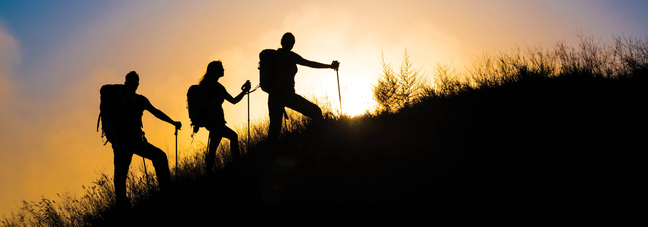 trio of hiker's going on an early morning hike with backpacks and walking sticks