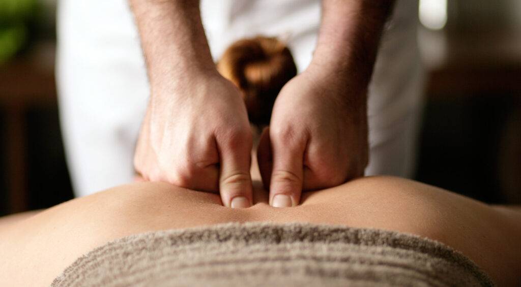 massage therapist giving a back massage to their patient