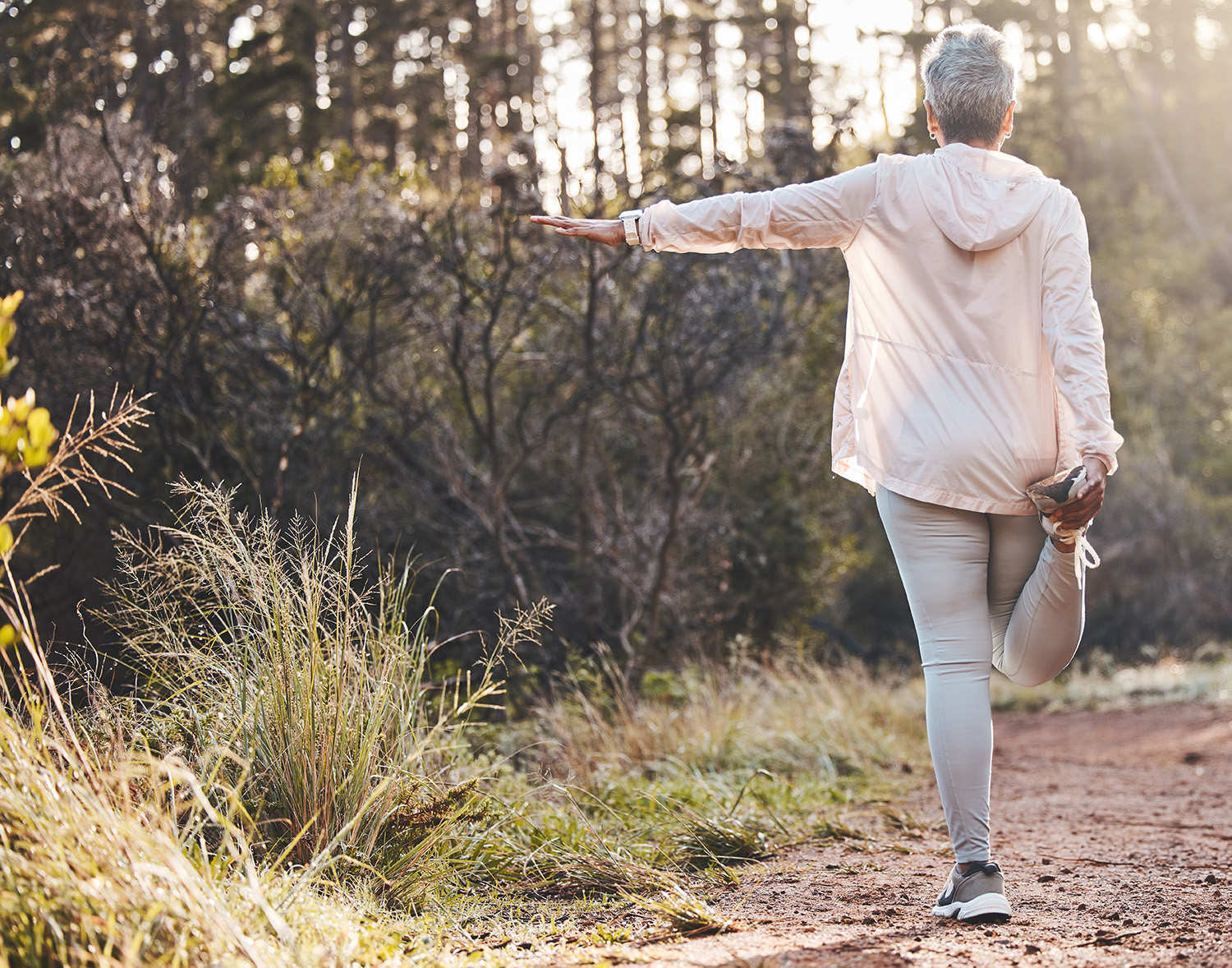 woman stopping to stretch her hamstrings during a walk