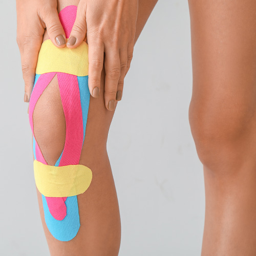 Athlete with kinesio tape applied around their right knee to help support the joint