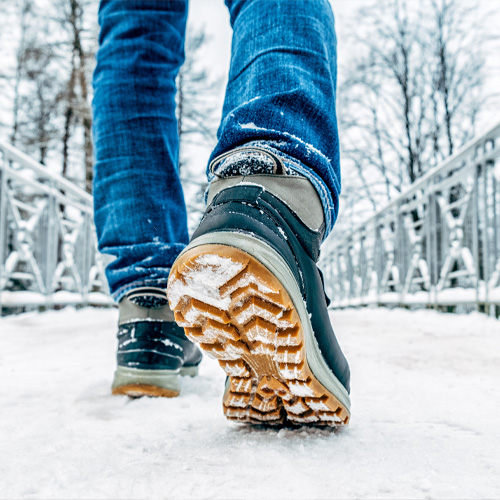 Man walking on a snowy bridge in winter boots