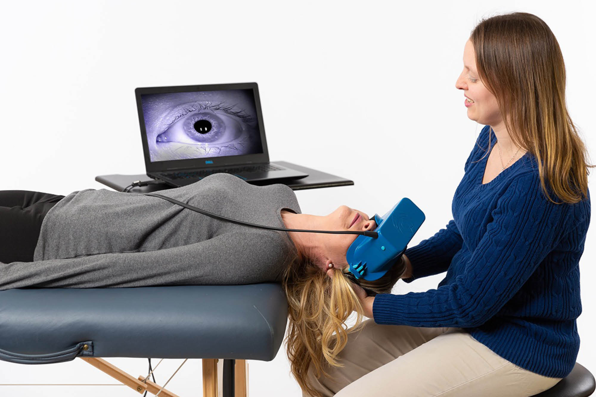 Physical therapist guides patient’s head during diagnostic exam for analyzing eye movements